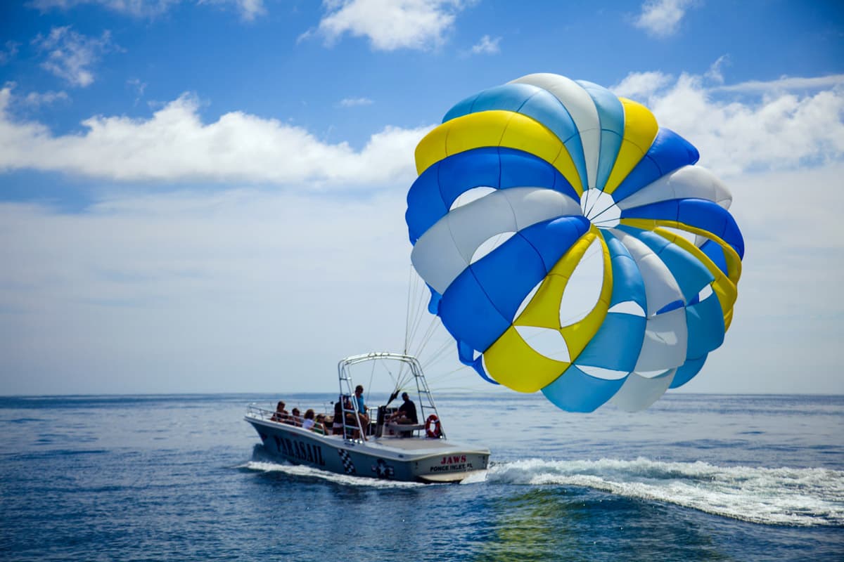 Two passengers parasailing over the Atlantic in tandem.