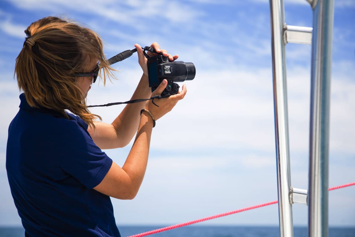 A guest photographing the Daytona coastline from the parasail boat.